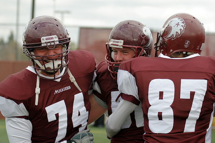 Augsburg's Bryce Vee (center) celebrates with teammates Alex Velasquez and Seth Elmquist after Vee recovered a fumble late in the fourth quarter of a game between Augsburg College and Carleton College on October 10, 2009 in Minneapolis, Minn. Augsburg won 31-28.