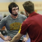 Concordia Moorhead 184 pound wrestler Chris Harrison listens to head coach Matt Nagel during pre match preparation for a match with Wartburg College at the NWCA national dual.