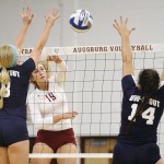Augsburg volleyball player Ashley Peper (19) spikes against UW-Stout's Becky Bradshaw (8) and Ashley Pratt (14) in the first set of a match between UW-Stout on September 11, 2014. Augsburg won 3-2 (25-12, 15-25, 25-18, 18-25, 15-9). Peper had 14 kills.